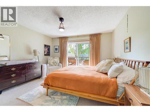 Primary Bedroom, with new lighting and sliding doors to private patio. - 983 Bernard Avenue Unit# 205, Kelowna, BC - Indoor Photo Showing Bedroom