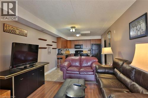 Living room featuring a textured ceiling and light wood-style floors - 776 Laurelwood Drive Unit# 705, Waterloo, ON - Indoor Photo Showing Living Room