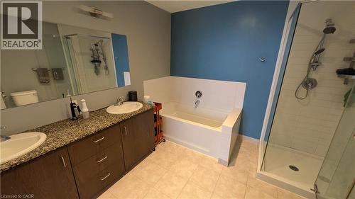 Bathroom with a stall shower, double vanity, a garden tub, and light tile patterned floors - 191 King Street S Unit# 213, Waterloo, ON - Indoor Photo Showing Bathroom