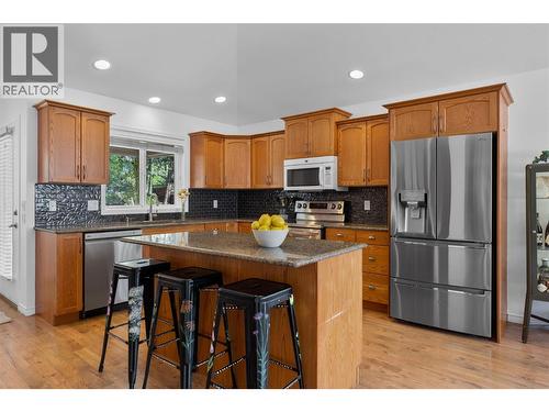 Granite counters and island with seating. - 1474 Rose Meadow Drive, West Kelowna, BC - Indoor Photo Showing Kitchen With Stainless Steel Kitchen With Double Sink