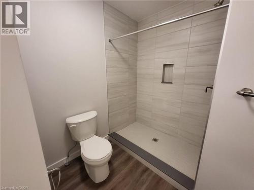 Bathroom featuring a shower stall and dark wood-type flooring - 118 Gravel Ridge Trail Unit# A8, Kitchener, ON - Indoor Photo Showing Bathroom