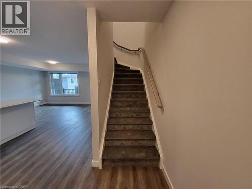 Stairway with baseboards and wood finished floors - 118 Gravel Ridge Trail Unit# A8, Kitchener, ON - Indoor Photo Showing Other Room