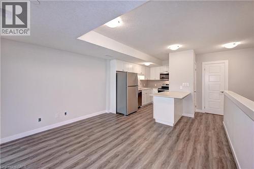 Kitchen featuring a peninsula, white cabinets, appliances with stainless steel finishes, light countertops, and open floor plan - 118 Gravel Ridge Trail Unit# C17, Kitchener, ON - Indoor Photo Showing Kitchen