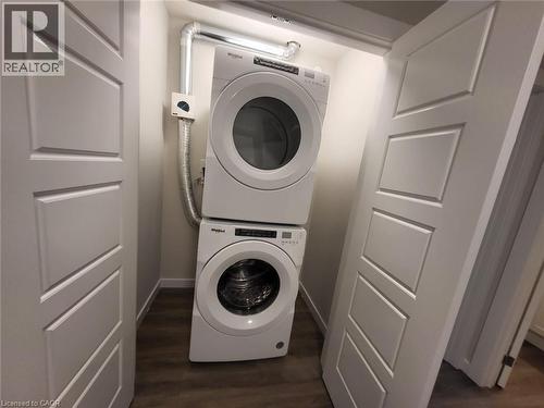 Washroom featuring stacked washer / dryer and dark wood-style flooring - 118 Gravel Ridge Trail Unit# B23, Kitchener, ON - Indoor Photo Showing Laundry Room