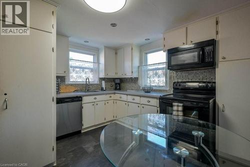 Kitchen featuring black appliances, light countertops, decorative backsplash, and healthy amount of natural light - 131 Elmwood Avenue, Cambridge, ON - Indoor Photo Showing Kitchen