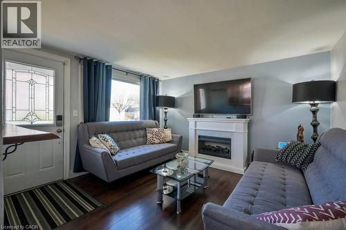 Living area featuring dark wood-type flooring and a fireplace - 131 Elmwood Avenue, Cambridge, ON - Indoor Photo Showing Living Room With Fireplace