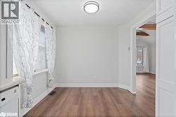 Empty room featuring dark wood-style flooring and baseboards - 