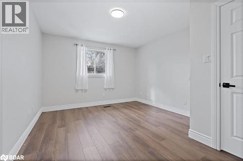 Spare room featuring dark wood-style floors and baseboards - 16 Bush Street, Collingwood, ON - Indoor Photo Showing Other Room