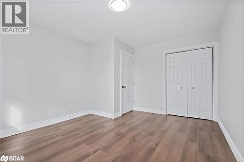 Unfurnished bedroom featuring wood finished floors and a closet - 16 Bush Street, Collingwood, ON - Indoor Photo Showing Other Room