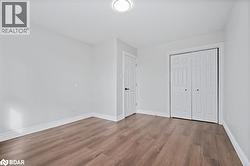 Unfurnished bedroom featuring wood finished floors and a closet - 