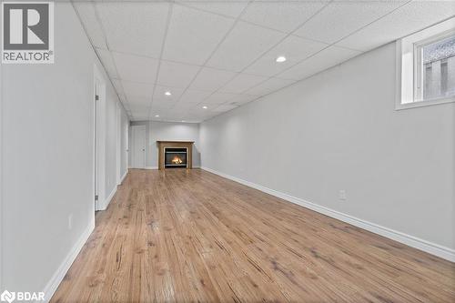 Finished below grade area featuring a paneled ceiling, recessed lighting, light wood-style flooring, and a lit fireplace - 16 Bush Street, Collingwood, ON - Indoor Photo Showing Other Room With Fireplace