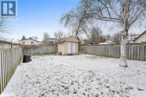Snowy yard featuring a fenced backyard, a shed, and a residential view - 16 Bush Street, Collingwood, ON - Outdoor With Backyard