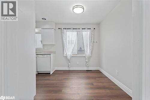 Unfurnished dining area with dark wood-type flooring and baseboards - 16 Bush Street, Collingwood, ON - Indoor Photo Showing Other Room