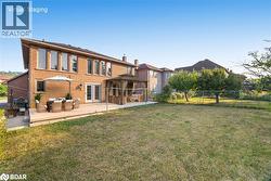 Rear view of property featuring a gazebo, a fenced backyard, an outdoor living space, and brick siding - 