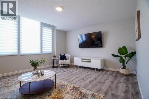 Living area with a textured ceiling and wood finished floors - 709 Rock Elm Street, Waterloo, ON - Indoor Photo Showing Living Room