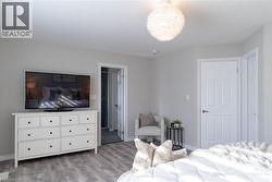 Bedroom featuring light wood-style floors and baseboards - 
