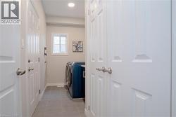 Laundry room with light tile patterned floors, washing machine and clothes dryer, and recessed lighting - 
