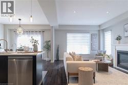 Living area featuring dark wood finished floors, a glass covered fireplace, healthy amount of natural light, a textured ceiling, and recessed lighting - 