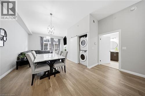 Dining space featuring light wood-style floors and stacked washer / dryer - 85 Morrell Street Unit# 102A, Brantford, ON - Indoor Photo Showing Laundry Room