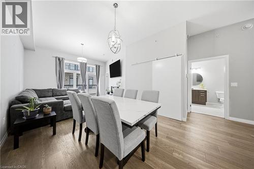Dining space featuring light wood-type flooring and a chandelier - 85 Morrell Street Unit# 102A, Brantford, ON - Indoor Photo Showing Dining Room