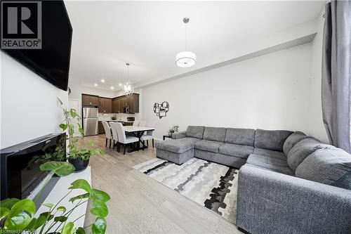 Living room featuring light wood-type flooring and a chandelier - 85 Morrell Street Unit# 102A, Brantford, ON - Indoor Photo Showing Living Room