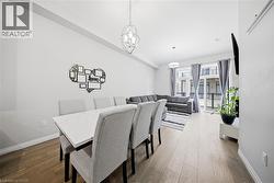 Dining area with dark wood-style floors and a chandelier - 