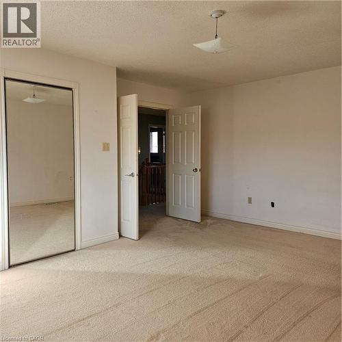 Unfurnished bedroom with a textured ceiling, a closet, and carpet - 115 Cranston Avenue, Cambridge, ON - Indoor Photo Showing Other Room