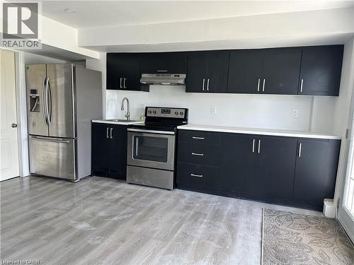Kitchen with dark cabinets, appliances with stainless steel finishes, light wood finished floors, and under cabinet range hood - 88 Bellhouse Avenue Unit# Bsmt, Brantford, ON - Indoor Photo Showing Kitchen
