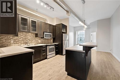 Kitchen with full size stainless steel appliances. Large island with bar height counters for eating - 31 Main Street Unit# 301, Cambridge, ON - Indoor Photo Showing Kitchen With Upgraded Kitchen