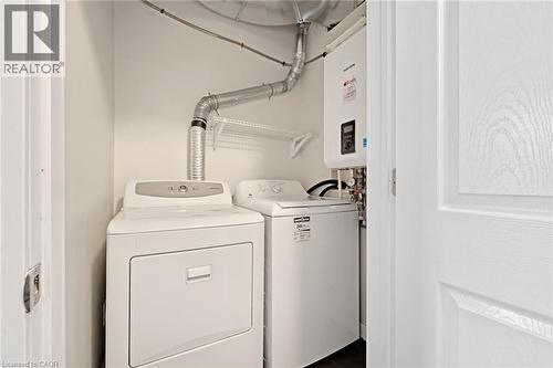 Laundry room featuring water heater and washer and clothes dryer - 31 Main Street Unit# 301, Cambridge, ON - Indoor Photo Showing Laundry Room