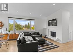 Bright open-concept living area with large windows and plenty of natural light. - 