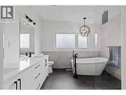 Luxury spa-like ensuite with walk-in tile shower, freestanding tub, and dual vanity. - 