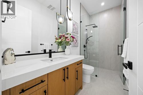 With a soaker tub, standing shower & double vanities - 1102 Carnoustie Drive, Kelowna, BC - Indoor Photo Showing Bathroom