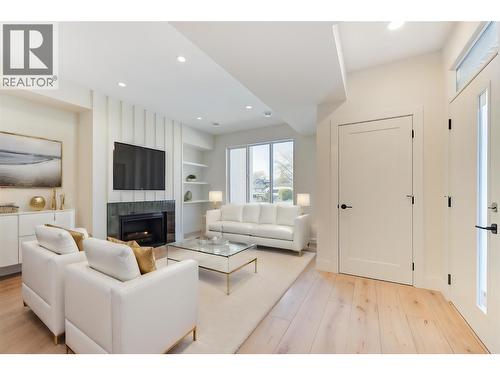 Virtually staged with fun design ideas - 857 Kinnear Court, Kelowna, BC - Indoor Photo Showing Living Room With Fireplace