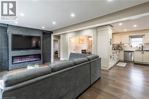 Living area with dark wood finished floors, recessed lighting, and a stone fireplace - 266 Melrose Avenue, Kitchener, ON - Indoor Photo Showing Living Room With Fireplace
