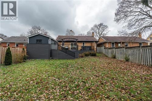 Rear view of house with a fenced backyard, a deck, stairs, and brick siding - 266 Melrose Avenue, Kitchener, ON - Outdoor