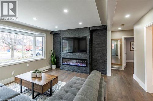 Living room with a fireplace, wood finished floors, plenty of natural light, and recessed lighting - 266 Melrose Avenue, Kitchener, ON - Indoor Photo Showing Living Room With Fireplace