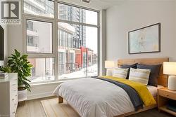 Bedroom with wood finished floors and multiple windows - 