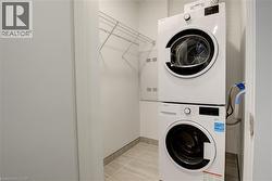 Washroom featuring stacked washing machine and dryer and baseboards - 