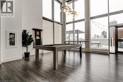 Recreation room with a high ceiling, expansive windows, a chandelier, baseboard heating, and billiards table - 