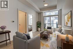 Living area with a tray ceiling and light wood finished floors - 