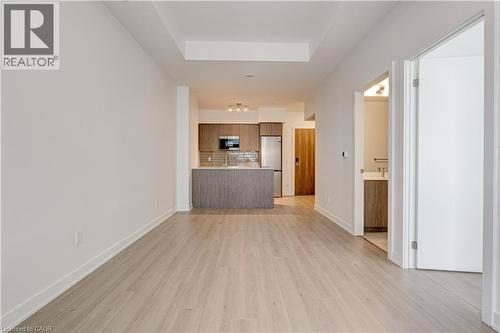Unfurnished living room with light wood-type flooring and a tray ceiling - 25 Wellington Street A S Unit# 209, Kitchener, ON - Indoor