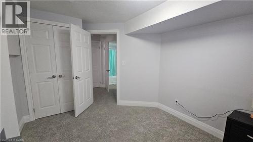Unfurnished bedroom featuring a closet, light carpet, and a textured ceiling - 10 Doll Court, Kitchener, ON - Indoor Photo Showing Other Room
