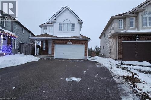 Traditional home featuring brick siding, an attached garage, and asphalt driveway - 10 Doll Court, Kitchener, ON - Outdoor