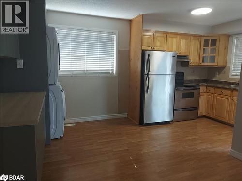 Kitchen featuring appliances with stainless steel finishes, dark countertops, light brown cabinetry, and light wood-style floors - 86 Overlea Crescent Unit# Main, Waterloo, ON - Indoor Photo Showing Kitchen