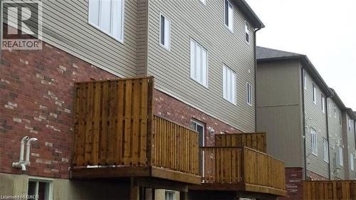 View of home's exterior featuring brick siding and a deck - 55 Mooregate Crescent Unit# 2, Kitchener, ON -  With Exterior
