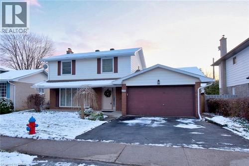 Traditional-style house with a chimney, brick siding, driveway, and an attached garage - 510 Cumberland Avenue, Burlington, ON - Outdoor