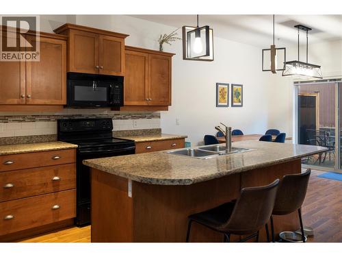 Island counter bar ledge - 10634 Powley Court Unit# 208, Lake Country, BC - Indoor Photo Showing Kitchen With Double Sink