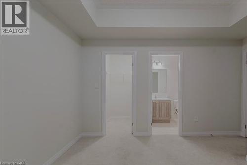 Empty room with light carpet, baseboards, and a sink - 25 Isherwood Avenue Unit# G105, Cambridge, ON - Indoor Photo Showing Other Room