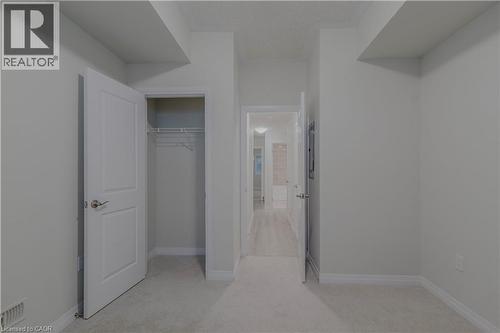Unfurnished bedroom featuring visible vents, baseboards, a closet, and light carpet - 25 Isherwood Avenue Unit# G105, Cambridge, ON - Indoor Photo Showing Other Room